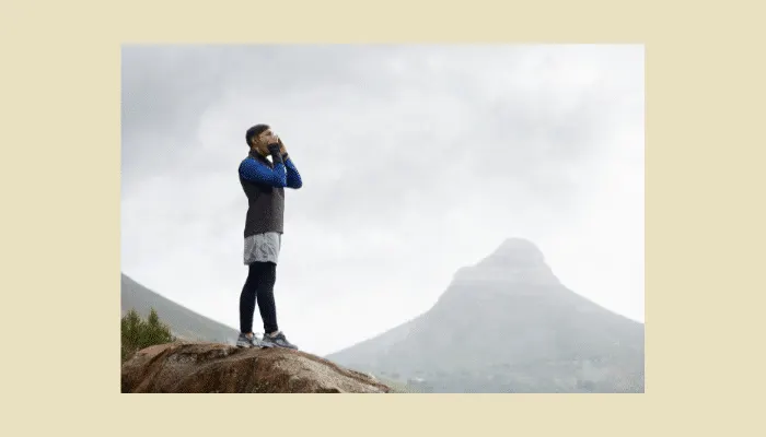 Person shouting into mountain canyon demonstrating natural echo effect that guitar delay pedals recreate.